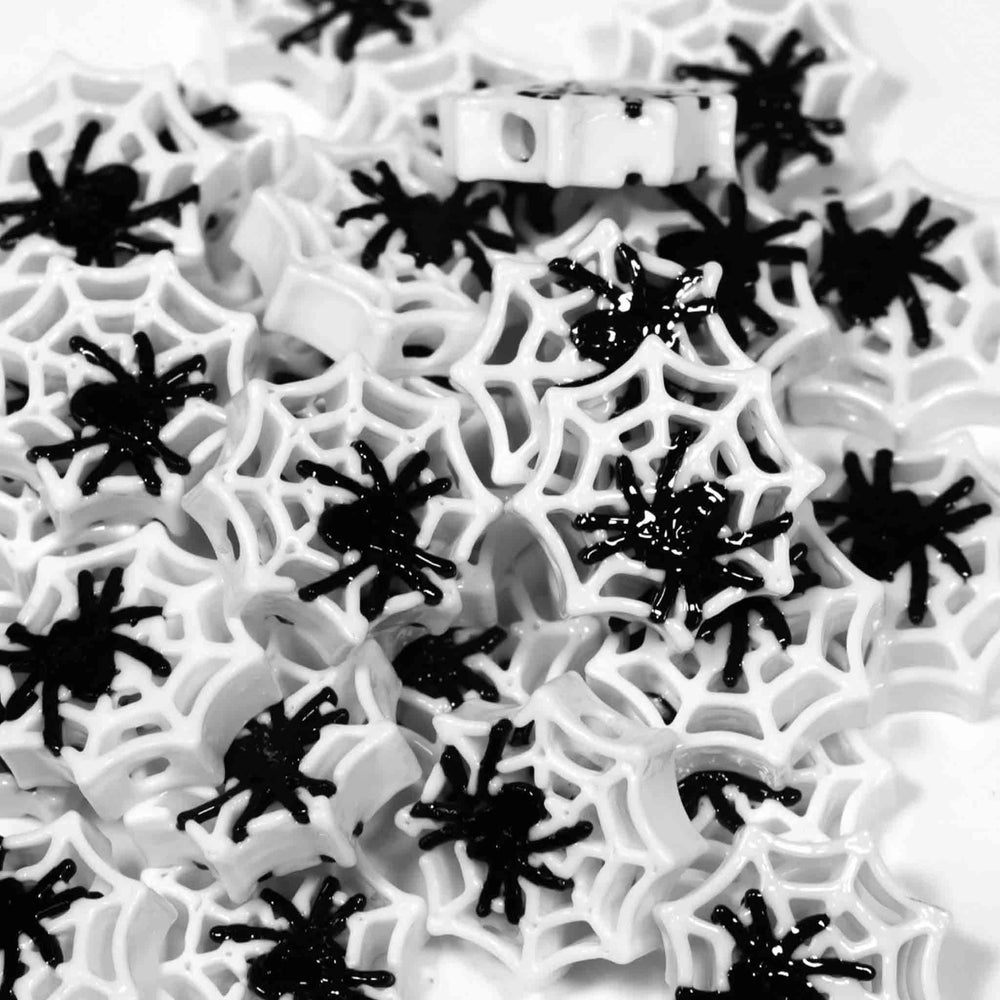 Black spiders on white spider webs, likely for Halloween decoration and kandi beads crafting.